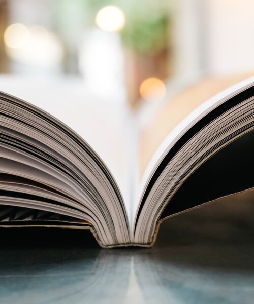 Aufgeschlagenes Buch in Nahaufnahme mit unscharfem Hintergrund.