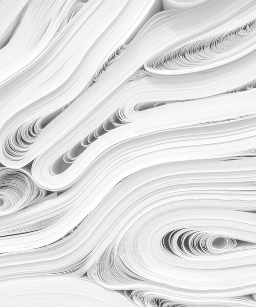 Gestapelte und geschwungene Papierbögen in abstraktem Muster.