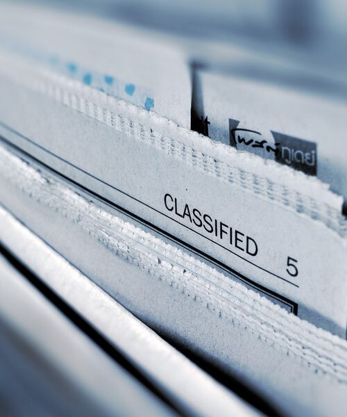Nahaufnahme von Dokumenten in einem Ordner mit der Aufschrift Classified.