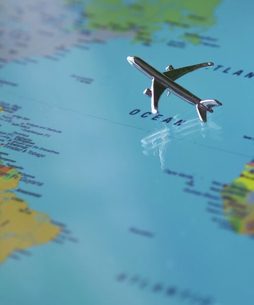 Kleines Flugzeugmodell auf einer Weltkarte über dem Atlantik.