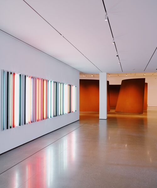 Moderne Kunstausstellung mit bunten Lichtinstallationen und großen Skulpturen.